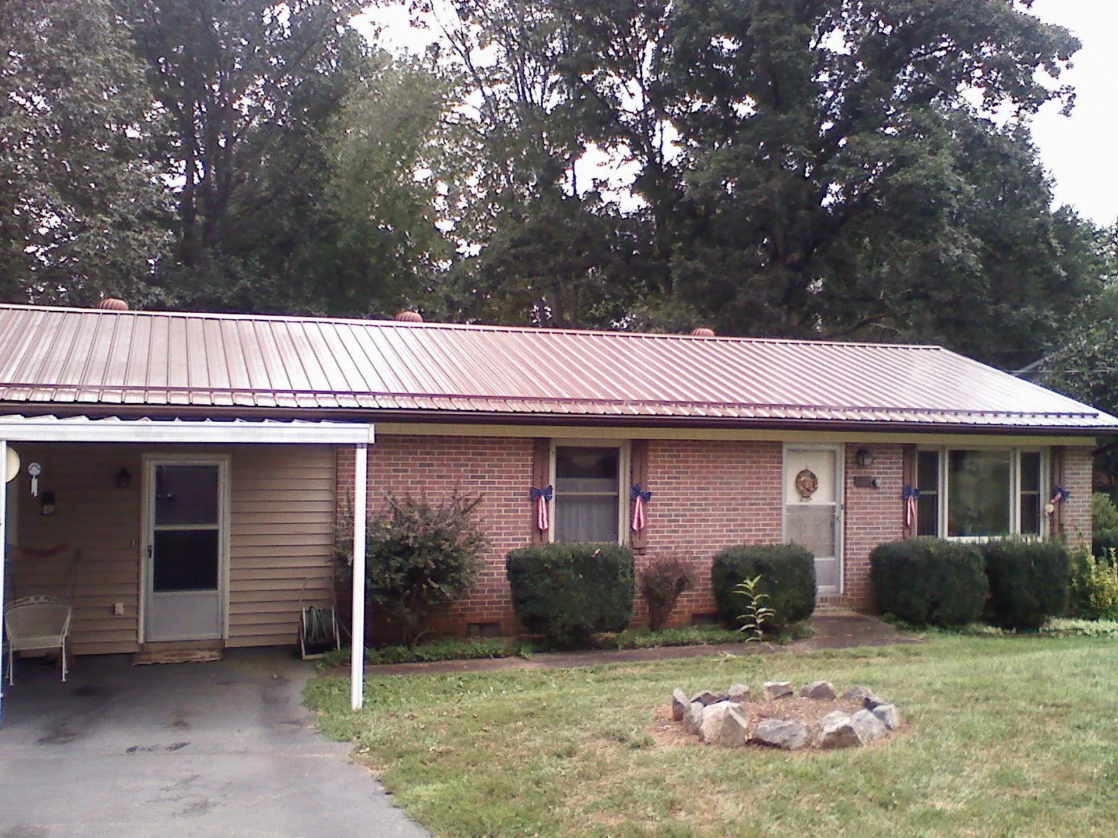 Bronze metal roof and carport on a brick ranch home — Roof Repair work by our crew in Harrison